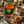 A jar of Bee Mercy Raw Honey Eucalyptus on a rustic wooden table, styled with a ceramic cup of tea, a honey dipper in a small bowl, and fresh eucalyptus leaves and flowers.