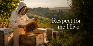 A person in a white beekeeping suit holds a honeycomb frame covered in bees beside wooden beehives, with rolling green hills and trees in the background. The text 'Respect for the Hive' appears on the right.