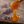 A wooden honey dipper filled with golden amber honey, with honey dripping down, set on a rustic stone surface with lavender sprigs in the background.